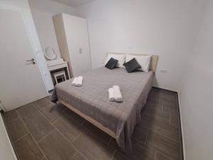 a bedroom with a bed with two slippers on it at Villa Leptirić in Vir +34 photos