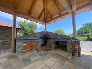 an outdoor fireplace in a patio with a roof at HEAVEN HOUSE in Kavala