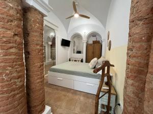 Un dormitorio con una cama y un ventilador de techo. en Atocha Boutique Badajoz, en Badajoz