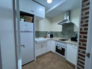 Una cocina blanca con fregadero y refrigerador. en Atocha Boutique Badajoz, en Badajoz 22 fotos más