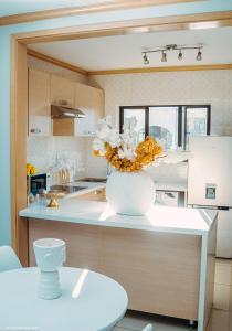 a kitchen with a vase of flowers on a counter at Sunset Gold-2 Bedrooms Apartment in Fourways