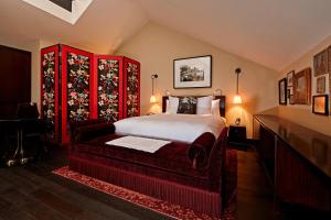 - une chambre avec un grand lit et un mobilier rouge dans l'établissement The Vagabond Club A Tribute Portfolio Hotel Singapore, à Singapour