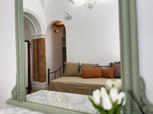 Un reflejo en el espejo de una cama en una habitación. en Atocha Boutique Badajoz, en Badajoz