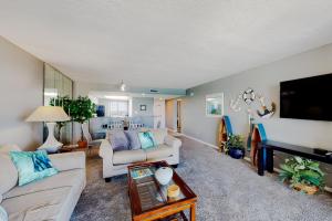 ein Wohnzimmer mit zwei Sofas und einem Fernseher in der Unterkunft Edgewater Beach Resort 1301 in Destin
