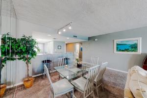 a dining room with a glass table and chairs at Edgewater Beach Resort 1301 in Destin