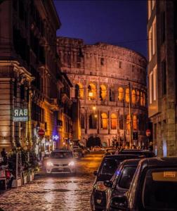 a city street with cars parked in front of a building at Laterano Apartment in Rome