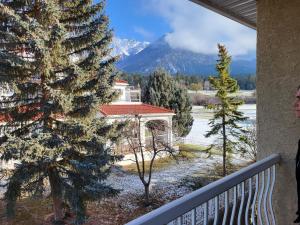 a woman standing on a balcony looking out at a snow covered mountain at Fairmont Mountain View Villas in Fairmont Hot Springs