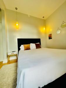 a bedroom with a large white bed and a side table at Plaza House Ílhavo in Ílhavo