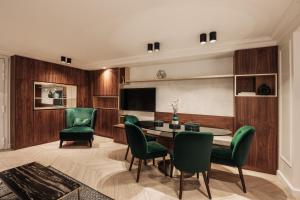 uma sala de estar com uma mesa e cadeiras verdes em HIGHSTAY - Luxury Serviced Apartments - Place Vendôme em Paris