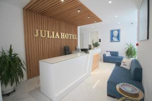 a lobby with a bar with a blue couch at Julia Hotel in Sarandë