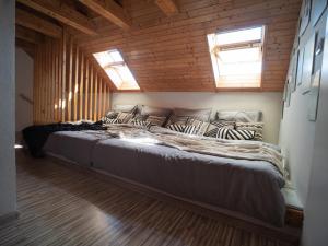 uma cama grande num quarto com paredes de madeira em Chata Laci na Kamenci em Kaluža