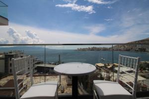 a balcony with a table and chairs and a view of the water at Julia Hotel in Sarandë