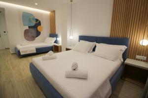 a bedroom with a large bed with two towels on it at Julia Hotel in Sarandë