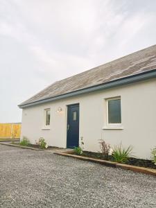 a white house with a blue door at The Cottage - Fairwinds in Doolin