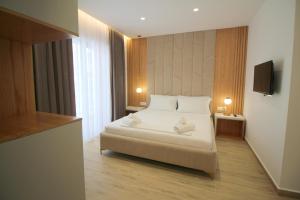 a hotel room with a bed and a television at Julia Hotel in Sarandë