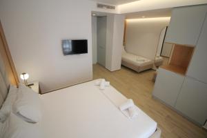 a white room with a bed and a bathroom at Julia Hotel in Sarandë
