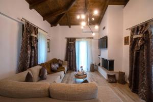 uma sala de estar com dois sofás e uma televisão em Lilaia's View em Lílaia