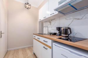 a kitchen with white cabinets and a counter top at Luna solari Apartment in Mantoúkion +4 photos
