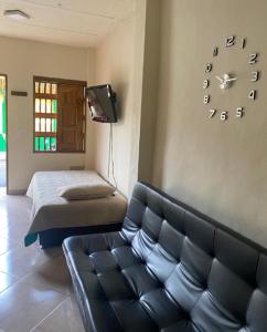 a living room with a couch and a clock on the wall at APARTAMENTO LOLACELE in Jardin