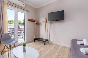 een woonkamer met een flatscreen-tv aan de muur bij Luna solari Apartment in Mantoúkion
