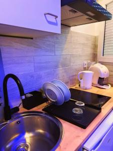 - un comptoir de cuisine avec évier dans l'établissement charmant studio, à Vaulx-en-Velin