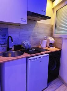 a kitchen with a sink and a washing machine at charmant studio in Vaulx-en-Velin