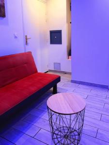 a red couch and a table in a room at charmant studio in Vaulx-en-Velin