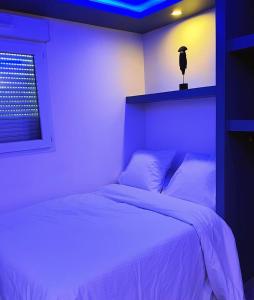 - une chambre avec un lit blanc et une tête de lit ornithologique dans l'établissement charmant studio, à Vaulx-en-Velin