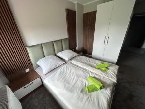 a bedroom with a bed with two green towels on it at Restauracja & Bar u Dudy in Chrząstowice