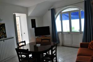 a living room with a table and a television at Appartamento di villa gesualda in Serrara Fontana