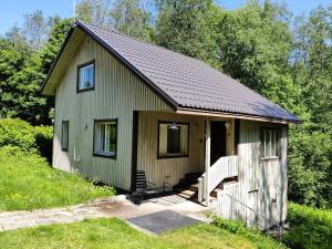 a small green house with a porch at Cozy cottage in Pontus in Lappeenranta