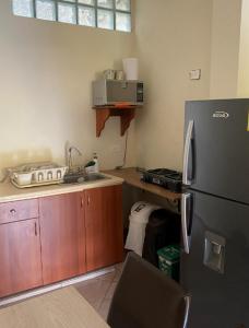 a kitchen with a black refrigerator and a sink at APARTAMENTO LOLACELE in Jardin
