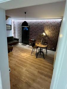 a living room with a table and a brick wall at North cosy house - Douai Centre in Douai +11 photos