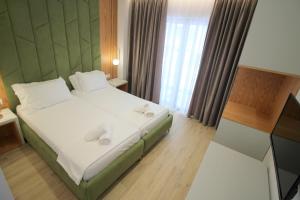 a bedroom with a large bed and a television at Julia Hotel in Sarandë