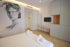 a room with a bed and a painting of a woman at Julia Hotel in Sarandë