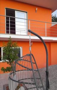 une cage pour oiseaux suspendue à une chaîne devant un bâtiment dans l'établissement Casa da Bela Vista, à Braga