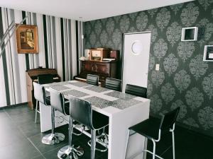 a dining room with a white table and green chairs at In Het Spoor Van De Vos in Zutendaal