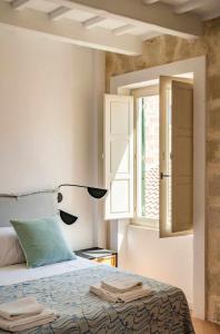 a bedroom with a bed with a lamp and a window at Casa Turqueta in Mahón