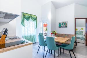 una cucina e una sala da pranzo con tavolo e sedie di Apartments Villa Rudi a Bibinje (Bibigne)