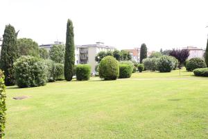 einen Park mit grünem Gras, Bäumen und Gebäuden in der Unterkunft Dreamich - Delle Rive in Desenzano del Garda