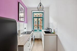 uma cozinha com paredes cor-de-rosa e brancas e uma janela em NEW Vintage Chic Apartment em Dresden