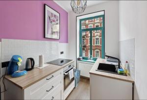 una cocina con paredes de color rosa y blanco y lavabo en NEW Vintage Chic Apartment en Dresden