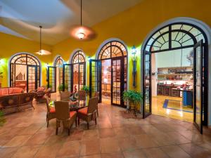 un restaurante con mesa y sillas en una habitación en Casa Oasis Guest House and Spa, en Mérida