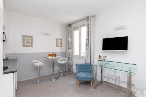sala de estar con mesa de cristal y silla azul en Elegant studio proche Palais des Festivals, en Cannes