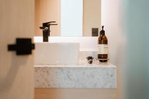 a bottle of wine sitting on a bathroom sink at Casa Lomah WTC in Mexico City +77 photos