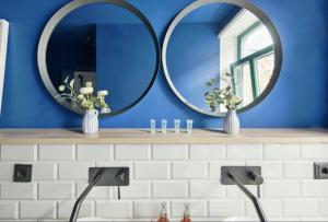ein Badezimmer mit zwei Spiegeln auf einer Theke mit einem Waschbecken in der Unterkunft NEW Vintage Chic Apartment in Dresden