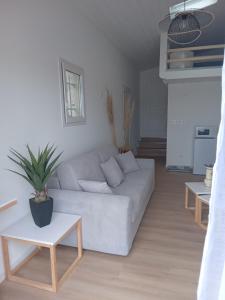 a living room with a white couch and two tables at L’Echappée Belle in Saint-Jean-de-Fos