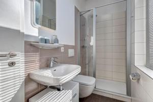 a bathroom with a sink and a toilet and a shower at Pension Portofino in Heringsdorf
