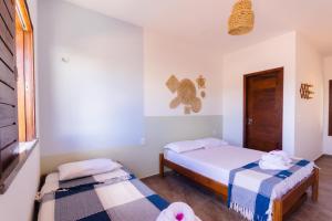 une chambre avec deux lits et une fenêtre dans l'établissement Vila Bella Barra Grande, à Barra Grande 18 autres photos