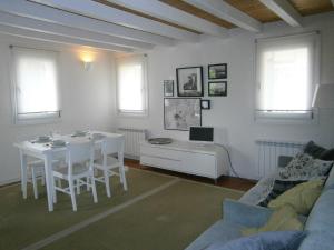 - un salon avec une table blanche et un canapé dans l'établissement Casa Incanto - Agenzia Cocal, à Caorle